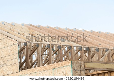 An ongoing construction site in the suburbs, featuring the framing stage of a single-family house.