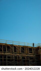 Ongoing Residential Building Construction With Worker On The Roof