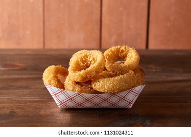 Onion Rings In A Basket On Dark Brown Surface