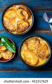 Onion Soup With Dried Bread And Cheese On Clay Bowls On Wooden Blue Background. Top View