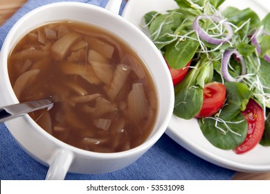 Onion Soup With Spoon And Side Salad.