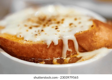 Onion soup and toast filled with melted cheese, close-up selective focus  - Powered by Shutterstock