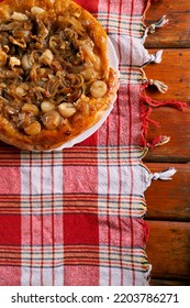 Onion Tarte Tatin With Potatoes And Feta Cheese Stands On A Plate On The Table