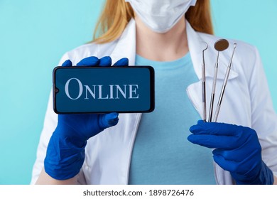 Online Appointment To Dentist From Your Phone. Female Doctor Holding Medical Instruments And Mobile Isolated Over The Blue Background.