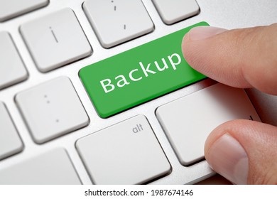 Online backup concept;Close-up of green color typing backup of male hand pressing computer keyboard.