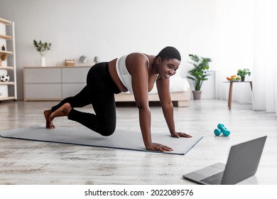 Online Bodyweight Exercises. Plus Size Afro Woman Having Strength Workout, Following Web Tutorial On Laptop, Running With Hands On Floor At Home. Curvy Black Lady Making Weight Loss Training