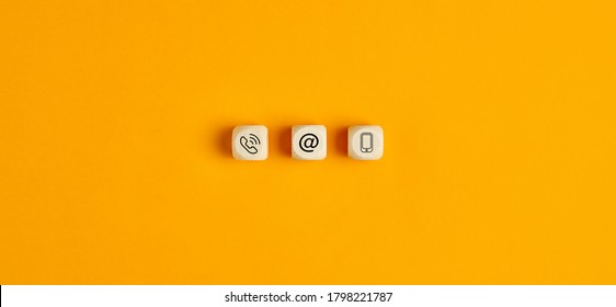 Online business communications concept with icons on wooden cubes on yellow background - Shutterstock ID 1798221787