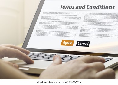 online business concept: man using a laptop with terms and conditions on the screen. Screen graphics are made up.
