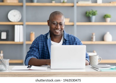 Online Career. Mature Black Male Freelancer Typing On Laptop. African American Man Wearing Glasses While Working On Computer, Sitting At Desk At Home Office, Enjoying Distance Job, Copy Space