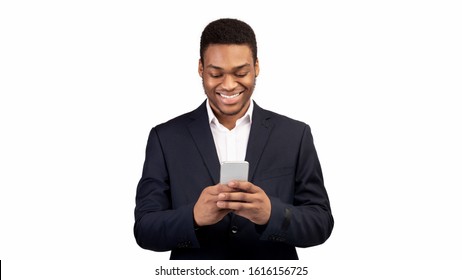 Online Chat. Happy Black Guy In Suit Using Mobile Phone, Texting Email To Clients, White Background, Panorama