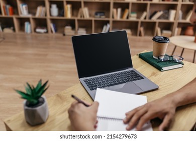 Online Class Concept. Male Student Writing In Notebook, Taking Notes And Using Laptop With Black Screen For Mockup Template, Watching Lecture Or Webinar At Home