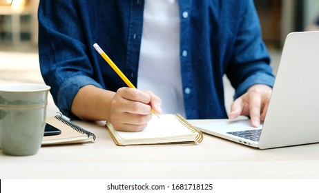 Online class, Student writing on notebook while study at home, Adult man doing online lesson by using laptop computer, Digital technology education, Work from home