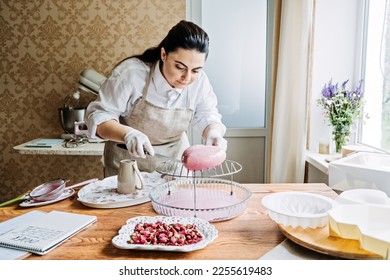 Online classes and workshops on cake decorating and baking. Female Confectioner baker make custom pink heart shape cake in kitchen Bakery. - Powered by Shutterstock