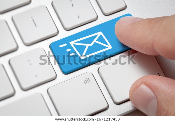 Online Communication concept: Macro male hand\
pressing computer key with e-mail illustration. Communication on\
internet globally\
concept.
