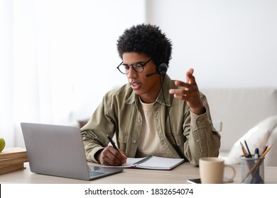 Online Communication And Education Concept. Serious Black Student Talking To His Teacher On Laptop From Home. African American Teenager Having Video Conference On Webcam