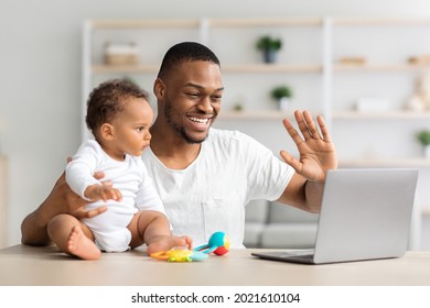 Online Communication. Happy Black Man And His Baby Son Making Video Call At Home, Using Laptop Computer For Remote Meeting With Family, Cheerful Man Waving Hand At Webcamera, Closeup Shot