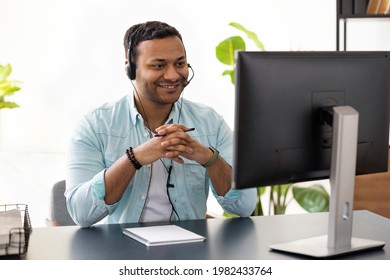 Online Communication. Happy Young Indian Millennial Man Uses Computer For Video Call Or Video Meeting, Call Center Employee, Advises Clients Online, Support Operator