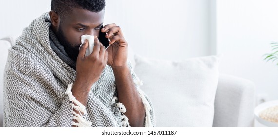 Online Consultation With Doctor. Sick African Man Calling Phone For Medical Help, Suffering From Cold And Seasonal Flu Virus, Empty Space