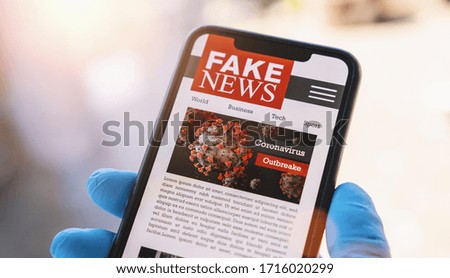 Online Corona Fake news on a mobile phone. Close up, man reading Fake news or articles about covid-19 in a smartphone screen application. Hand with gloves holding smart device. COVID19 nCov Outbreak.