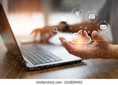 Online Data Collection Technology Concept, Man Use Laptop Woking And Keep Data In Cloud Storage  Technology For Data Security From Damage And Holding A Smartphone In Blur Background