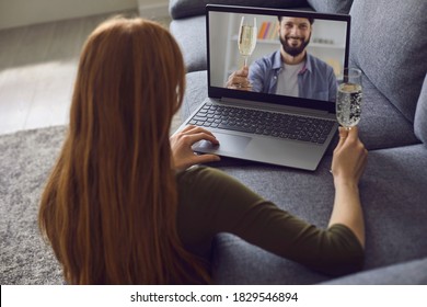 Online date dating. A young woman is in a living room with a laptop. On the laptop screen a handsome young man with a glass of wine. Virtual distance communication virtual love. Video chat from a - Powered by Shutterstock