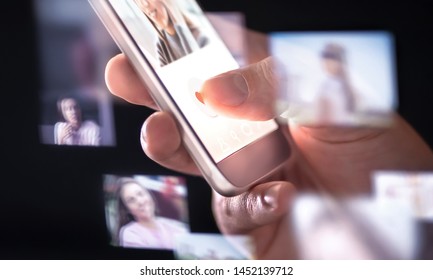 Online Dating App Or Site In Mobile Phone. Finding Love And Romance From Internet With Smartphone. Man Giving Like. Many Hologram Photos Of Beautiful Woman Around Cellphone. Stalker Looking At Profile