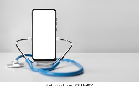 Online doctor. Mobile phone mockup for medical app. Smartphone white screen mockup and stethoscope for health application. App health phone mockup. Banner with copy space - Shutterstock ID 2091164851