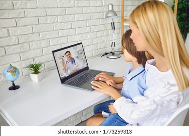 Online Doctor. Patient Mother With A Child Has A Video Call Consultation To A Doctor Therapist Sitting At A Table In A Living Room.