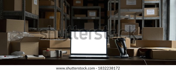 Online ecommerce store mockup, dropshipping\
business website concept. Table with laptop computer mock up blank\
white screen, shipping boxes, retail marketplace, warehouse\
delivery background,\
banner.
