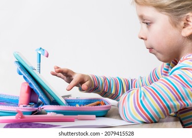 Online Education For Children. The Girl Is Reading An E-book. The Child Draws In Online Courses. Modern Technology And Home Education