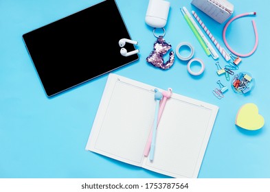 Online Education Concept. Tablet, Phone, Headphones, Notebook, School Supplies On Blue Background. Distance School In Quarantine. View From Above With Copy Space. Mockup, Flatlay
