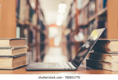 Online education course, E-learning class and e-book digital technology concept with pc computer notebook open in blur school library or classroom background among old stacks of book, textbook archive