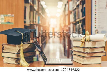 Online education course, E-learning class and e-book digital technology concept with pc computer notebook open in blur school library or classroom background among old stacks of book, textbook 