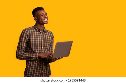 Online Education Programs. Black Millennial Guy With Laptop In Hands, Yellow Background