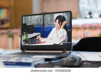 Online Education of Student learning study meeting concept : Attractive girl Beautiful Asian talking smartphone using laptop calling teacher video communication for e-learning or distant learning