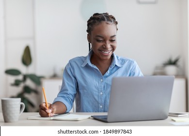 Online Education. Young Black Female Student Using Laptop At Home And Taking Notes, Smiling African American Woman Enjoying Distance Learning, Watching Webinar In Internet, Copy Space