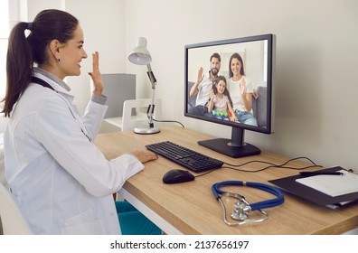 Online Family Doctor At Desk With Stethoscope Smiling And Waving Hello At Desktop Computer Screen Greeting Parents And Child At Telemedicine Consultation Via Video Call In Modern Convenient Webcam App