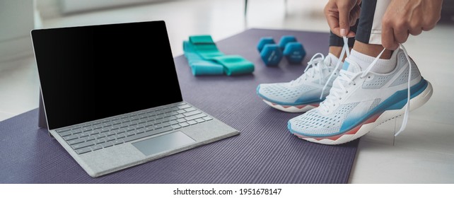 Online Fitness Class At Home Banner. Woman Getting Ready To Train Hiit Workout With Laptop Screen For Streaming. Tying Her Shoe Laces Panoramic.