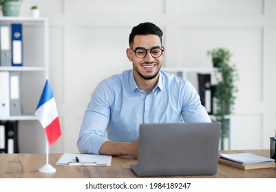 Online Foreign Languages Tutoring. Cheerful Arab Male Teacher Giving French Class, Communicating On Laptop From Home. Experienced College Professor Giving New Material To Students On Web