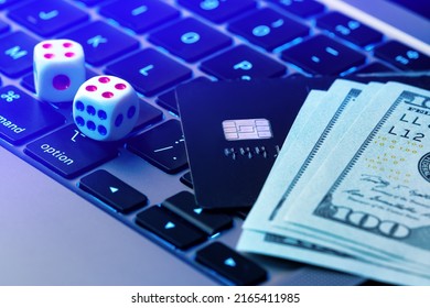 Online gambling background. Making profit with online casino, online gaming concept. Game dice, credit card and dollars lie on a modern laptop keypad close-up. - Shutterstock ID 2165411985