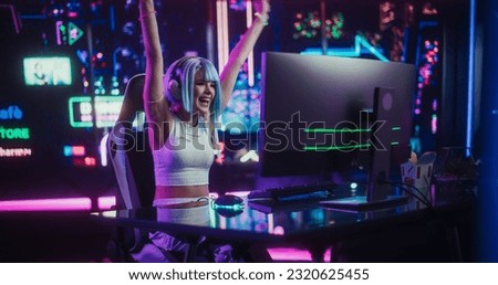 Online Gamer Playing a Video Game in a Futuristic Cyberpunk Room. Cosplay Girl with Blue Hair Using Headphones, Talking with Players During the Game Stream. Pro Gamer Winning and Celebrating