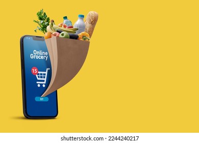 Online grocery app on smartphone and full grocery bag coming out of the smartphone screen, copy space