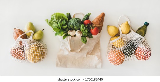 Online grocery healthy shopping. Flat-lay of fruit, vegetables, greens, bread and oil in eco-friendly bag over white background, top view. Shop online during pandemic of coronavirus banner for website - Powered by Shutterstock