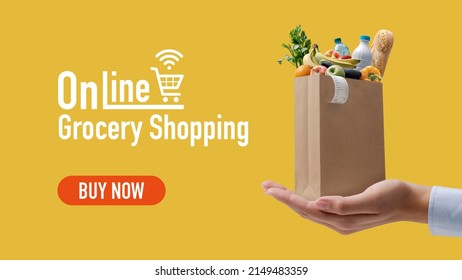 Online Grocery Shopping And Home Delivery: Hand Holding A Tiny Grocery Bag Full Of Goods