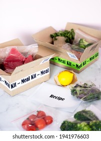 Online Home Food Delivery. Craft Box With Packed Tuna, Shrimp, Vegetables And Recipe Card On A Kitchen Background. Food Delivery Services During Coronavirus Pandemic And Social Distancing.