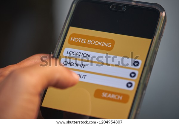 Online hotel booking and online travel
concept. Male hands using smartphone for holiday vacation deal on
mobile reservation app. Front view & close up. All screen
graphics are made up with own
design