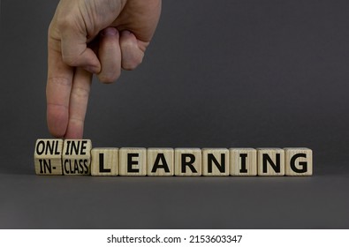 Online or in-class learning symbol. Businessman turns cubes, changes words online learning to in-class learning. Grey background. Education and online or in-class learning concept. Copy space.