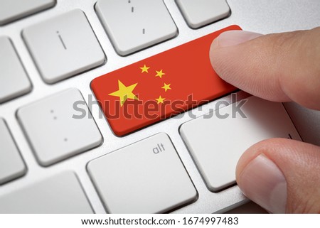 Online International Business concept: Computer key with the China flag on it. Male hand pressing computer key with China flag.