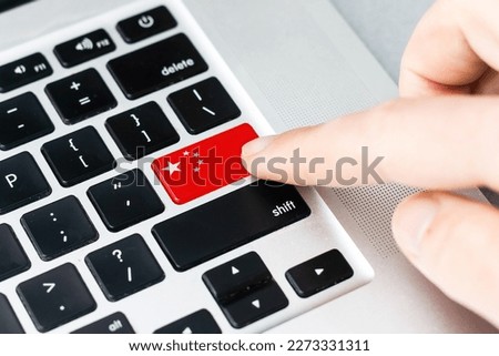 Online International Business concept: Computer key with the China flag on it. Male hand pressing computer key with China flag