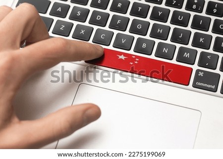 Online International Business concept: Computer key with the China flag on it. Male hand pressing computer key with China flag